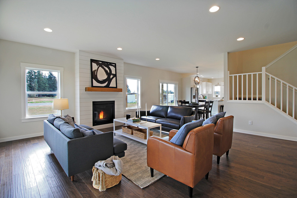 This is an example of a large traditional open plan living room in Seattle with grey walls, dark hardwood flooring, a standard fireplace and a wooden fireplace surround.