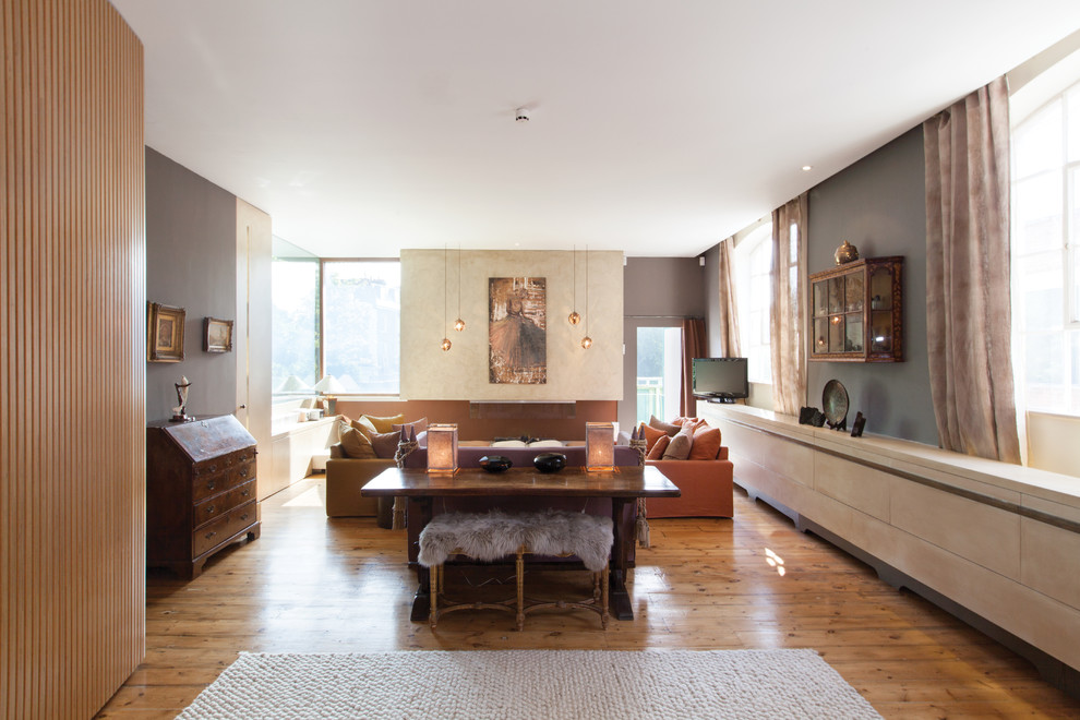 Diseño de salón para visitas abierto bohemio grande con paredes beige, suelo de madera en tonos medios y chimenea lineal