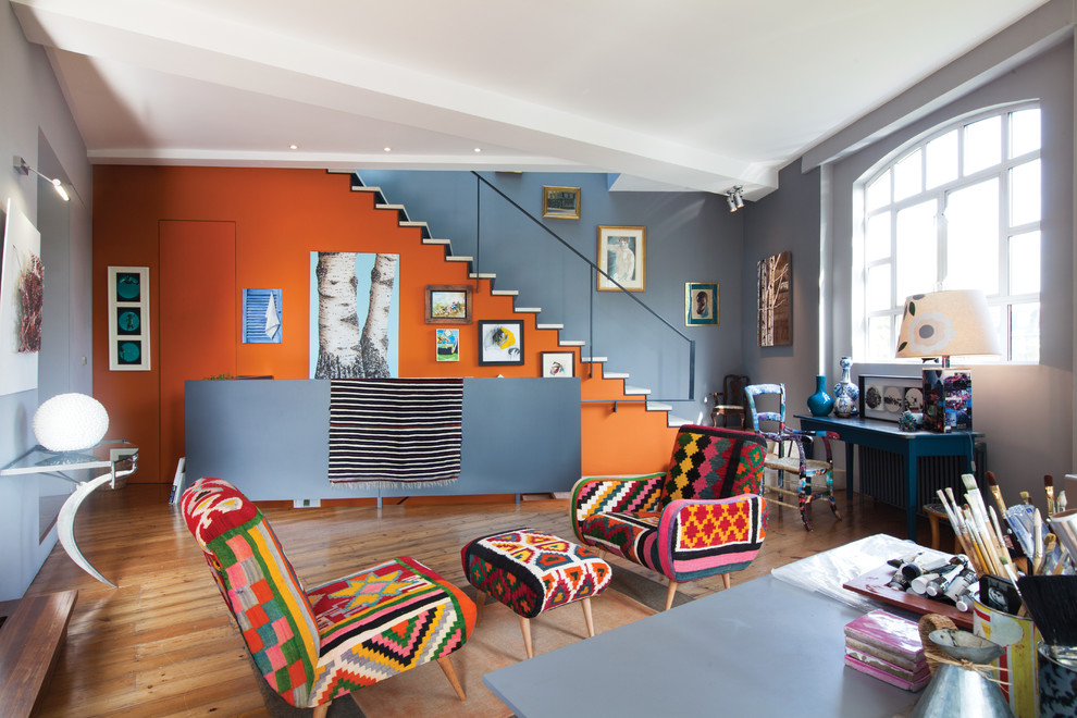 Immagine di un ampio soggiorno bohémian aperto con sala formale, pareti multicolore e pavimento in legno massello medio