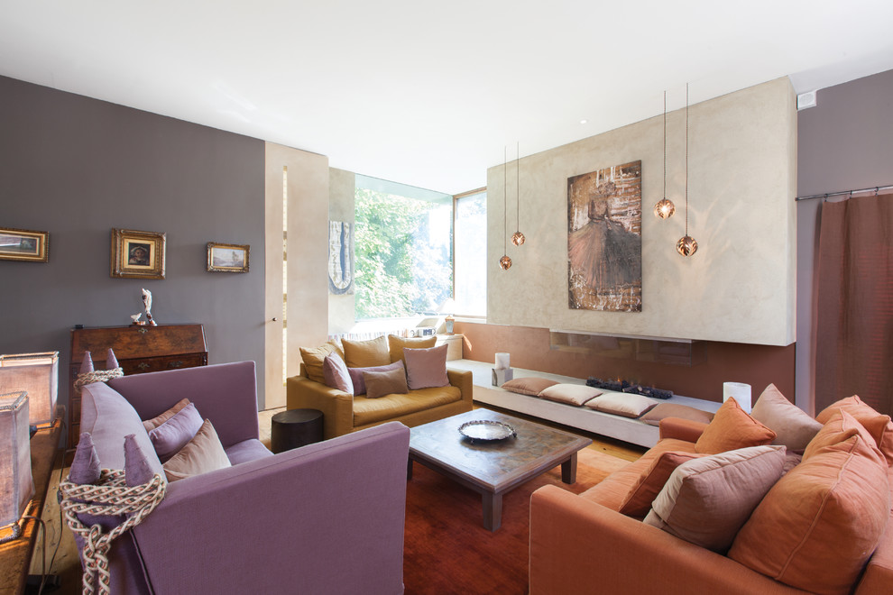 Foto de salón para visitas abierto bohemio grande con paredes multicolor, suelo de madera en tonos medios y chimenea lineal