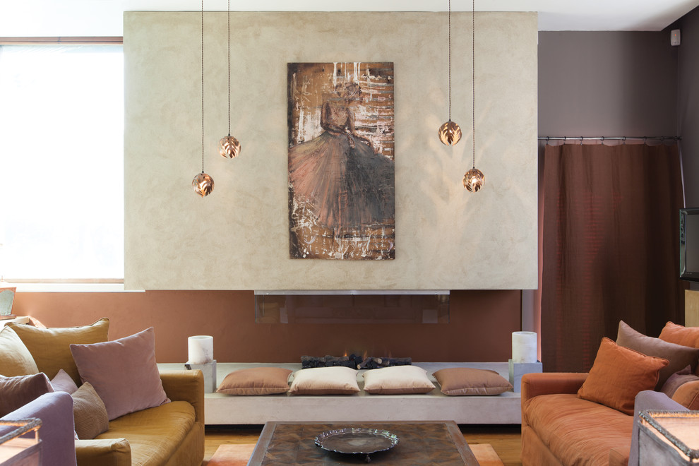 Foto de salón para visitas abierto bohemio grande con paredes grises, suelo de madera en tonos medios y chimenea lineal
