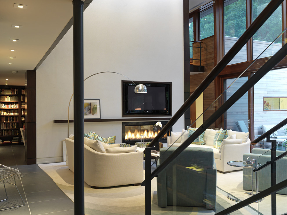 На фото: гостиная комната:: освещение в современном стиле с белыми стенами, горизонтальным камином и телевизором на стене
