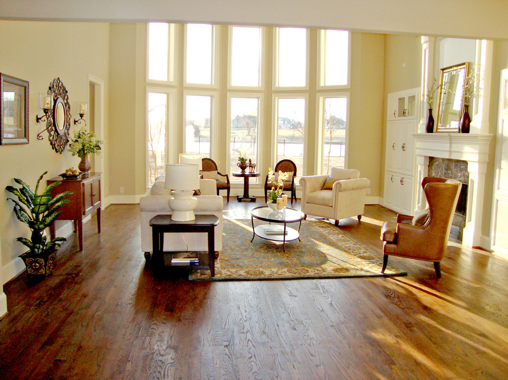 Aménagement d'un très grand salon classique ouvert avec une salle de réception, un mur beige, un sol en bois brun, une cheminée standard, un manteau de cheminée en bois et un téléviseur dissimulé.