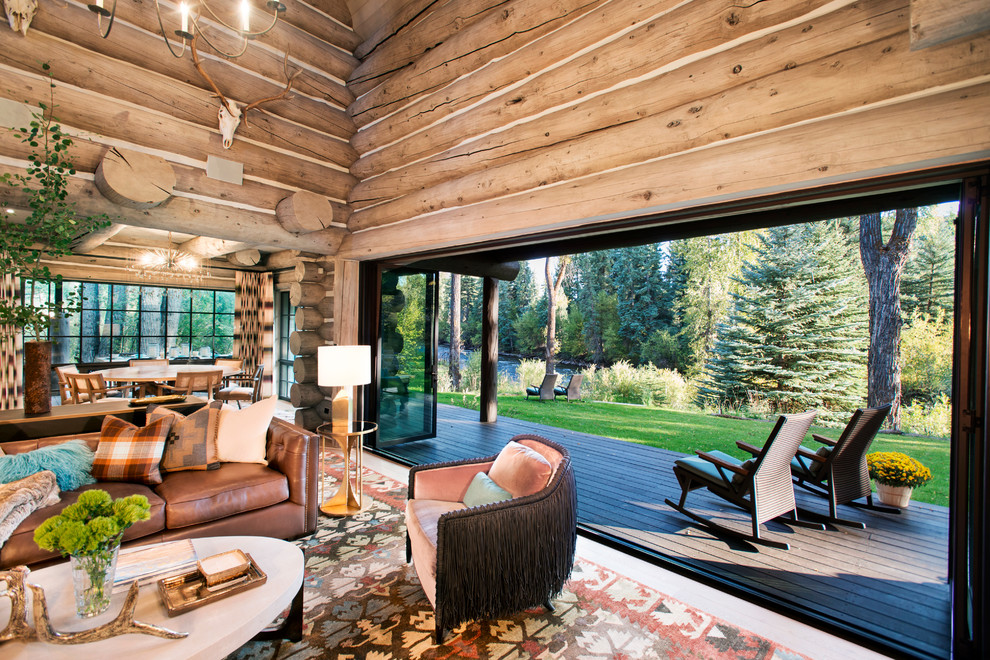 Esempio di un ampio soggiorno stile rurale aperto con pareti marroni e pavimento in legno massello medio