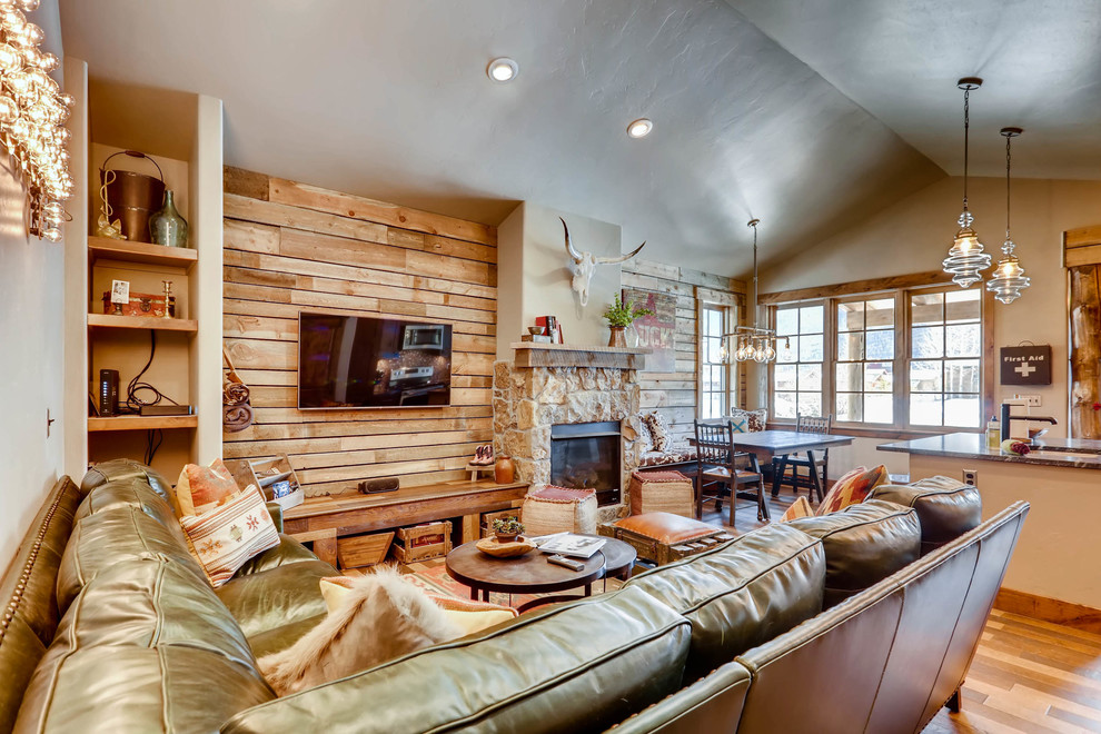 Inspiration for a small rustic open plan living room in Denver with brown walls, dark hardwood flooring, a standard fireplace, a stone fireplace surround, a wall mounted tv and brown floors.