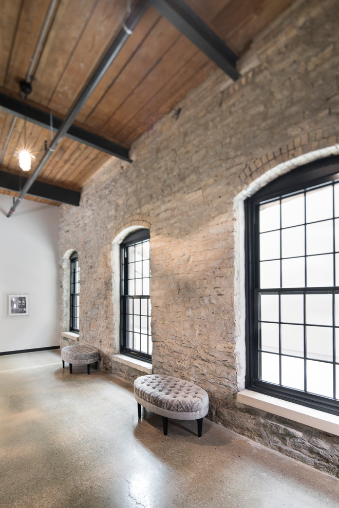 Mittelgroßes, Repräsentatives, Abgetrenntes Industrial Wohnzimmer mit weißer Wandfarbe, hellem Holzboden und braunem Boden in Milwaukee