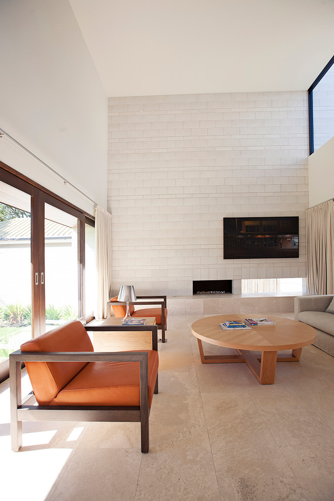 Cette image montre un salon design avec une salle de réception, un mur blanc, une cheminée double-face et un téléviseur fixé au mur.