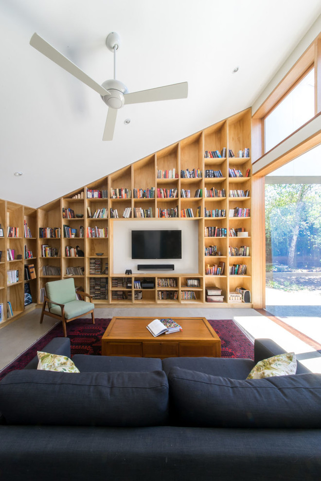 Immagine di un soggiorno minimal chiuso con libreria, pareti bianche, TV a parete e pavimento grigio