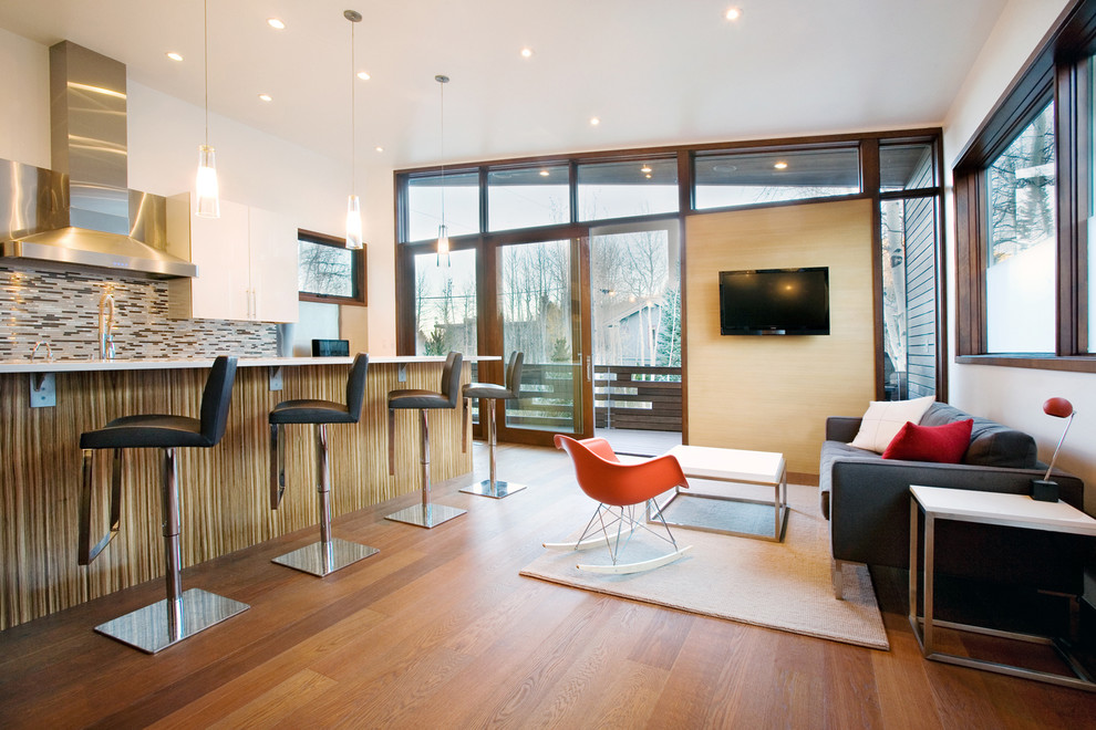 На фото: гостиная комната среднего размера в стиле модернизм с телевизором на стене
