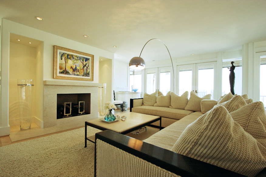 Cette photo montre un grand salon tendance ouvert avec un mur beige, parquet clair, une cheminée standard et un manteau de cheminée en pierre.