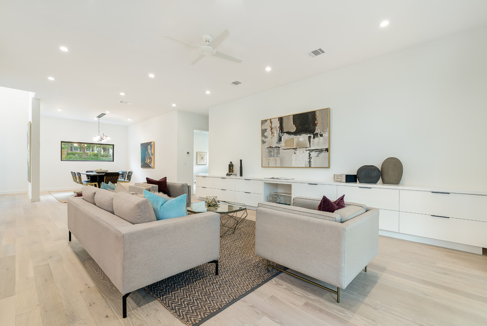 Example of a mid-sized trendy open concept and formal light wood floor and brown floor living room design in Austin with white walls, no fireplace and no tv