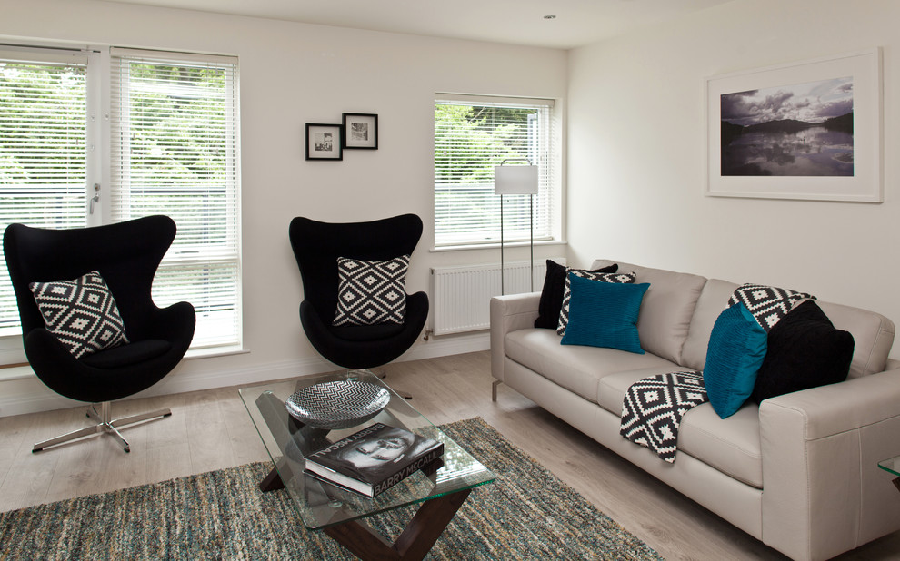 Mittelgroßes, Repräsentatives, Offenes Modernes Wohnzimmer ohne Kamin mit weißer Wandfarbe, hellem Holzboden und freistehendem TV in Dublin