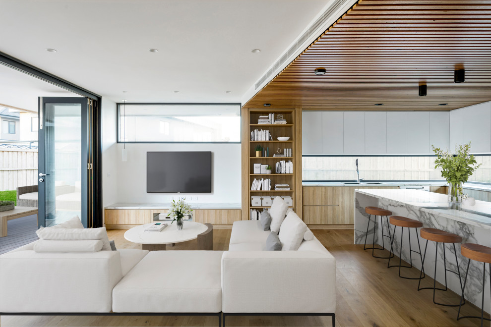 Foto di un grande soggiorno design aperto con libreria, pareti bianche, parquet chiaro, TV a parete, pavimento marrone e soffitto in perlinato