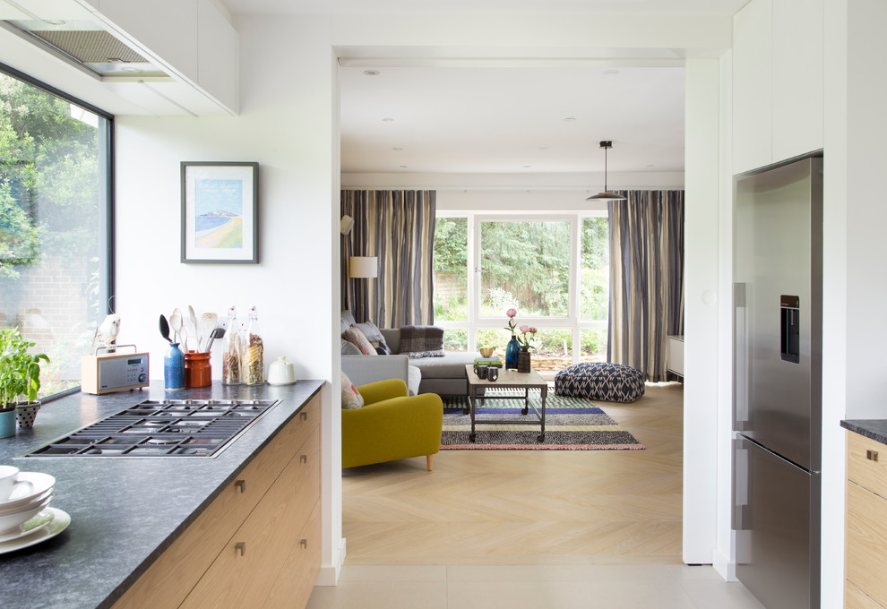 Mittelgroßes, Offenes Stilmix Wohnzimmer mit hellem Holzboden, Kaminofen, Kaminumrandung aus Beton und beigem Boden in London