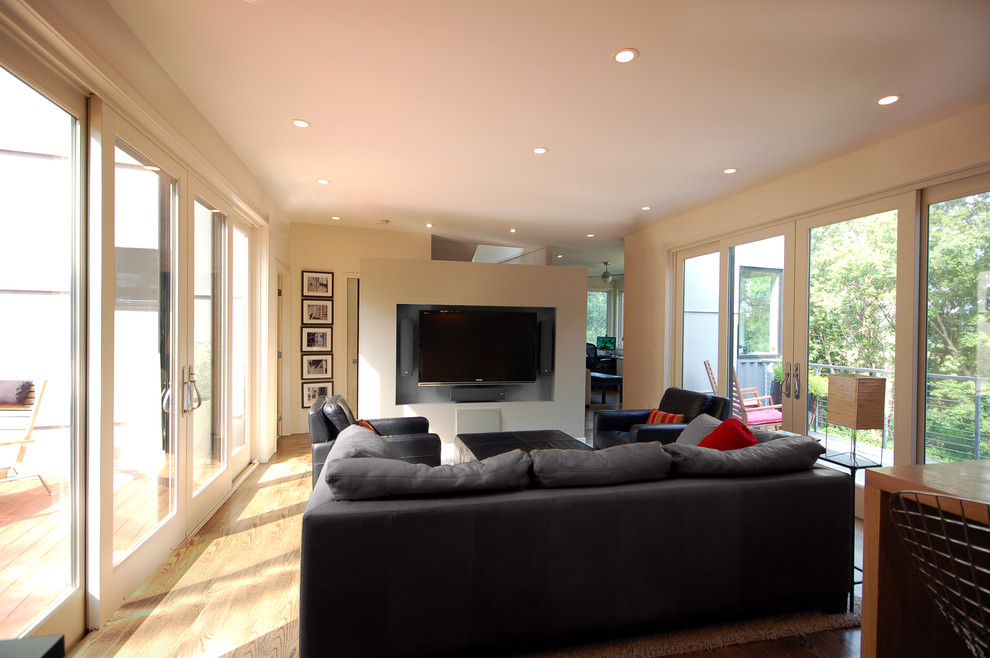 Esempio di un soggiorno minimalista aperto con pareti bianche, parquet scuro e TV a parete