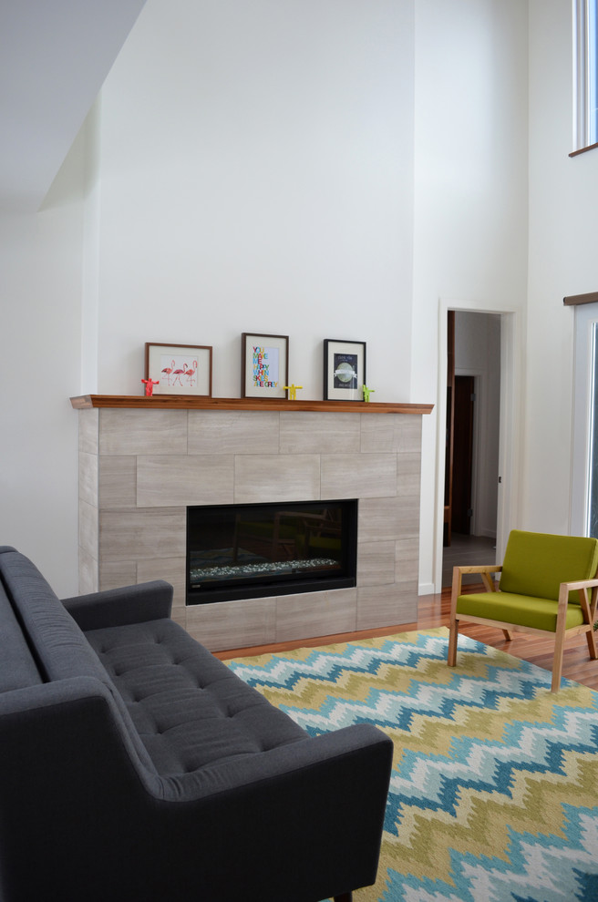 Inspiration for a modern open concept medium tone wood floor living room remodel in Calgary with white walls, a standard fireplace and a tile fireplace