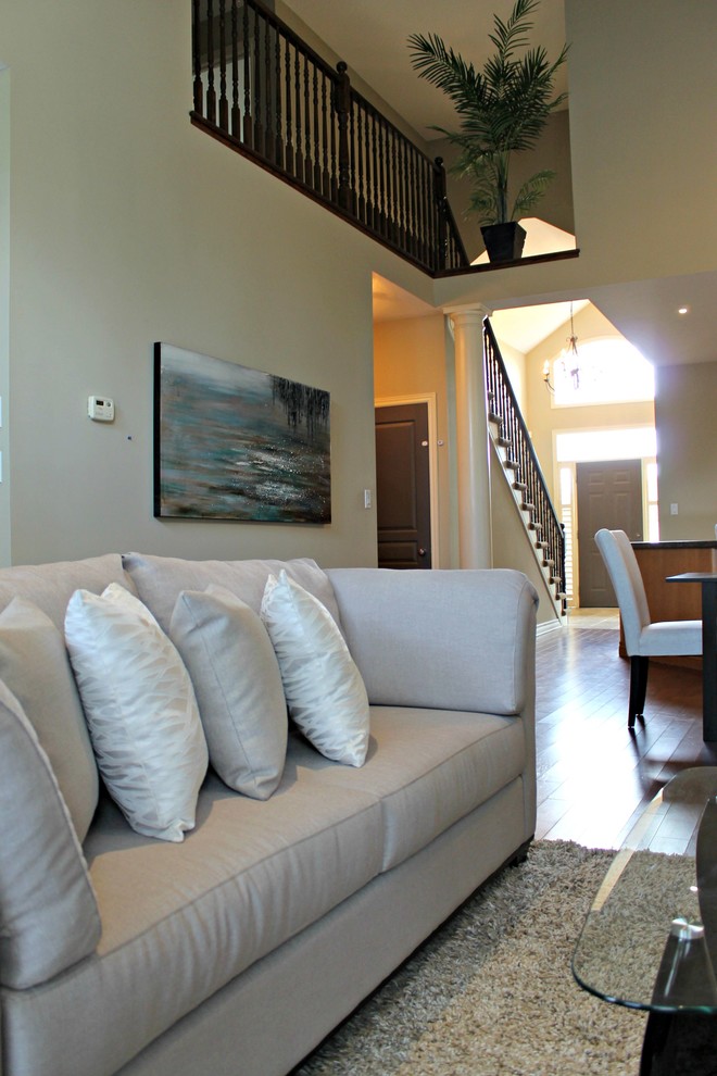 Immagine di un grande soggiorno minimal aperto con pareti beige, pavimento in legno massello medio, camino classico e cornice del camino in legno