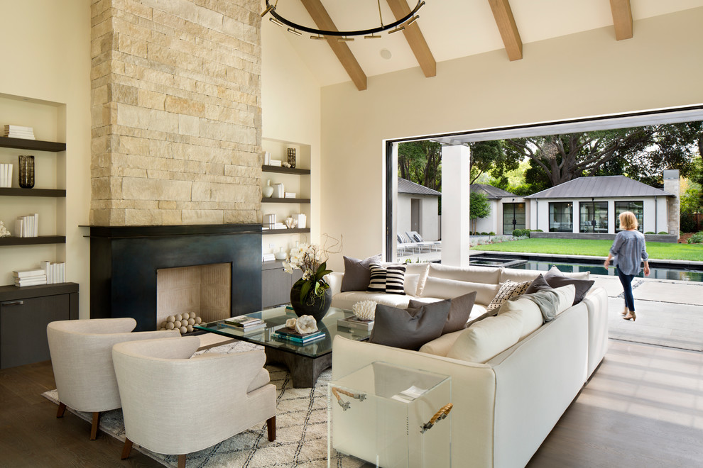 Repräsentatives, Offenes Modernes Wohnzimmer mit beiger Wandfarbe, dunklem Holzboden, Kamin, braunem Boden und Steinwänden in Orange County