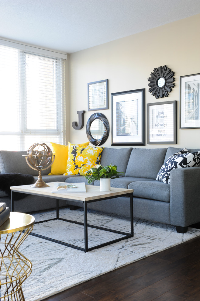 This is an example of a small contemporary living room in Vancouver with grey walls, medium hardwood flooring and a wall mounted tv.