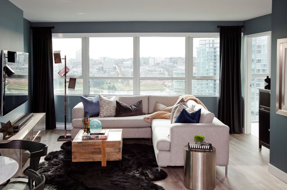Immagine di un soggiorno design con pareti blu, pavimento con piastrelle in ceramica, pavimento beige e TV a parete