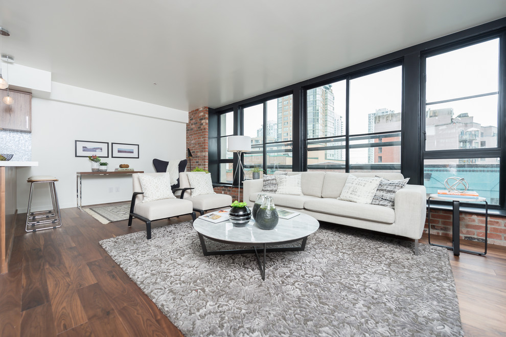 Mittelgroßes, Repräsentatives, Fernseherloses Modernes Wohnzimmer im Loft-Stil mit weißer Wandfarbe, dunklem Holzboden, Kamin, Kaminumrandung aus Metall und braunem Boden in Vancouver