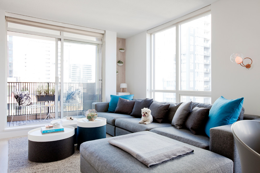 Esempio di un piccolo soggiorno minimalista aperto con sala formale, pareti bianche, parquet chiaro e TV a parete