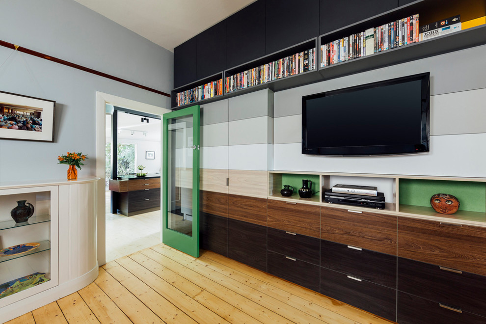 Bild på ett mellanstort funkis separat vardagsrum, med grå väggar, ljust trägolv, en inbyggd mediavägg och brunt golv