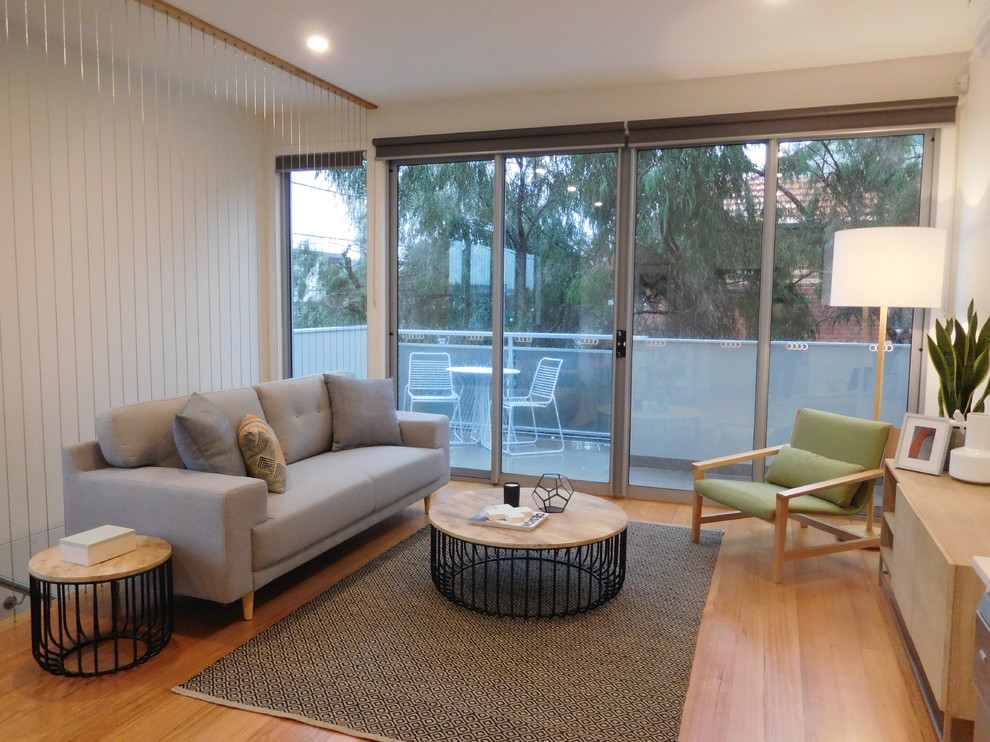 Foto di un piccolo soggiorno design aperto con pareti bianche e pavimento in legno massello medio