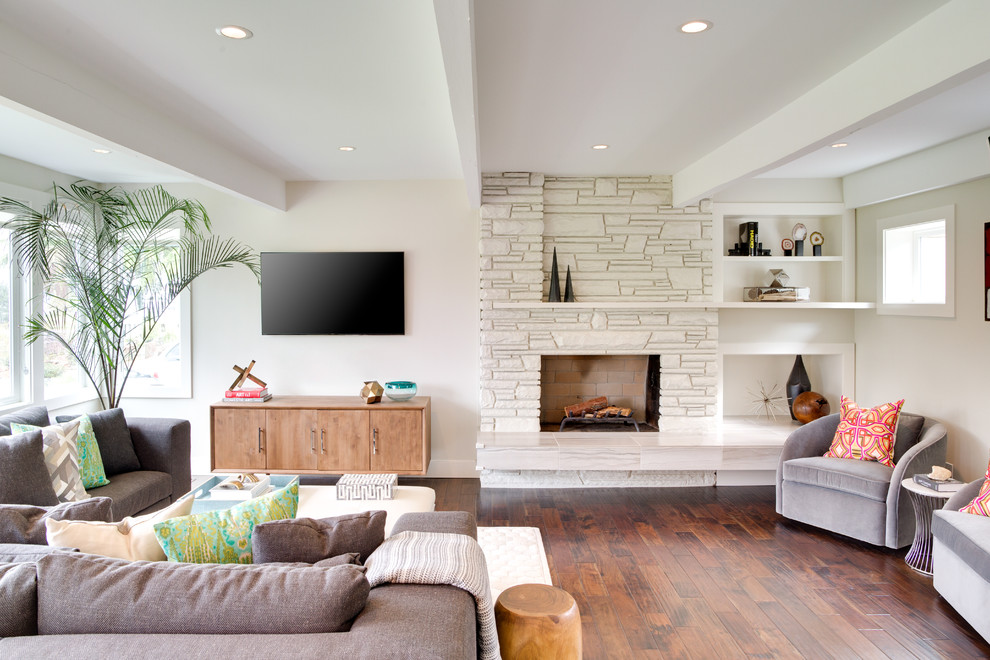 Mittelgroßes, Offenes Modernes Wohnzimmer mit weißer Wandfarbe, dunklem Holzboden, Kamin, Kaminumrandung aus Stein und TV-Wand in Seattle