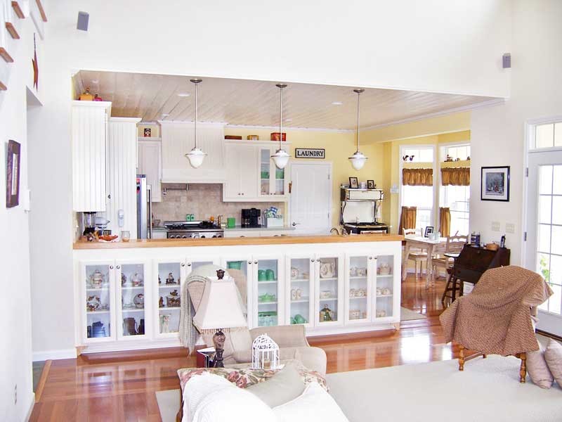 Modelo de salón abierto de estilo de casa de campo grande con paredes blancas y suelo de madera en tonos medios