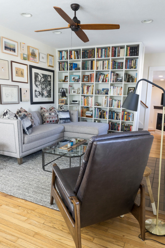 Ispirazione per un soggiorno classico con libreria, pareti bianche, parquet chiaro e pavimento beige