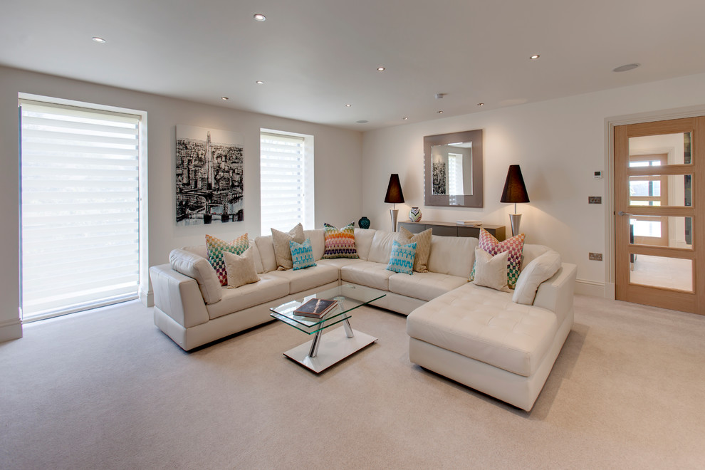 Immagine di un grande soggiorno moderno chiuso con angolo bar, pareti grigie, moquette, camino classico, TV a parete e pavimento beige