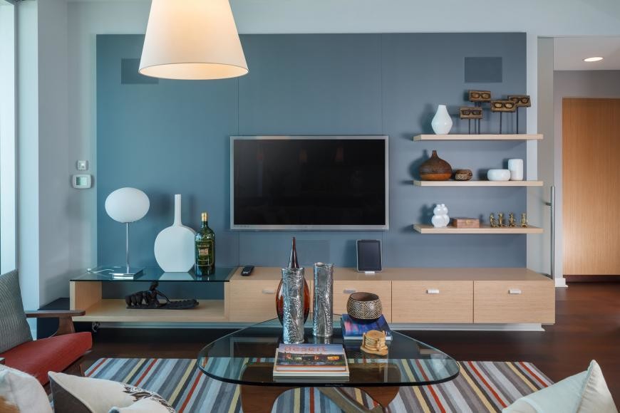Exempel på ett mellanstort asiatiskt allrum med öppen planlösning, med en hemmabar, blå väggar, mörkt trägolv och en väggmonterad TV