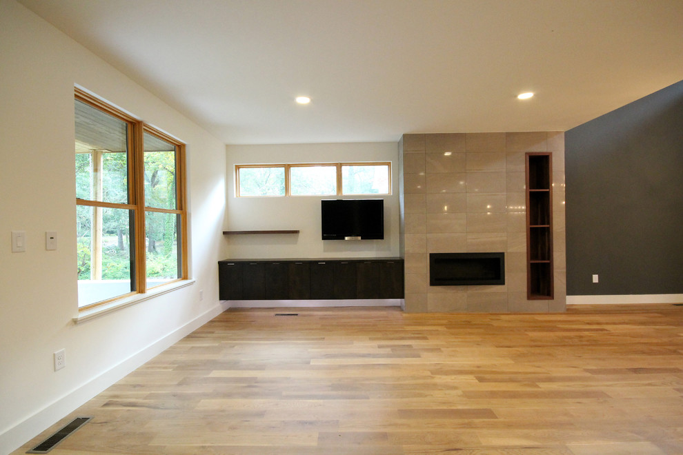 Idéer för att renovera ett vintage vardagsrum, med vita väggar, ljust trägolv, en spiselkrans i trä och en väggmonterad TV