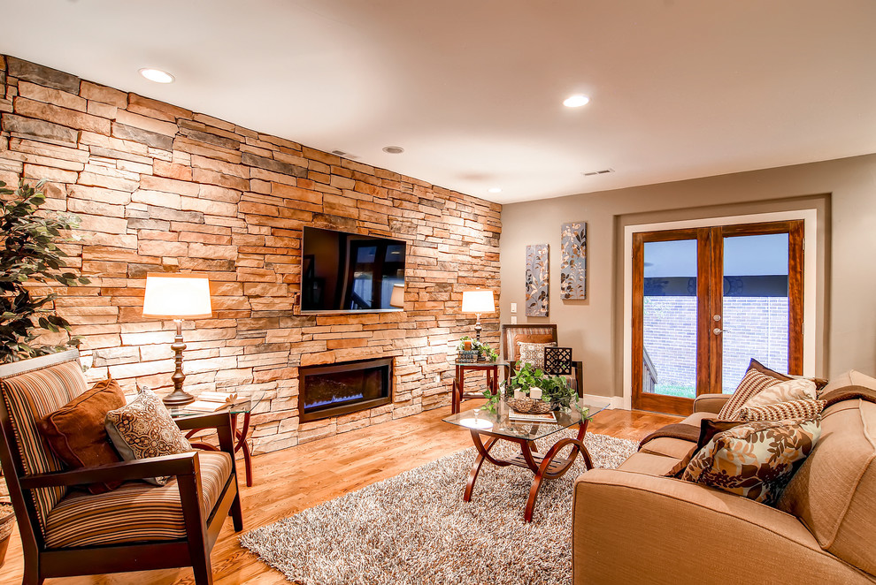 Klassisches Wohnzimmer mit Gaskamin, Kaminumrandung aus Stein, TV-Wand und Steinwänden in Denver
