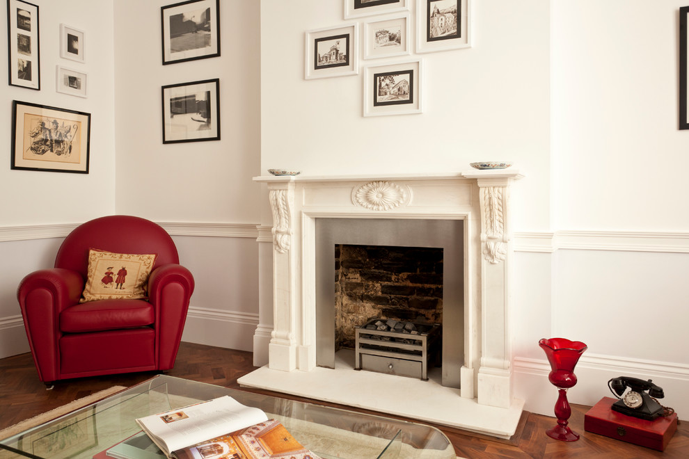 Photo of a midcentury living room in London with a stone fireplace surround.