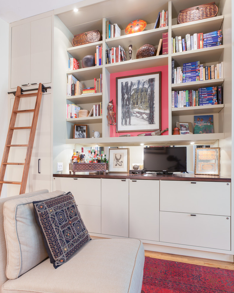 Idee per un piccolo soggiorno bohémian aperto con libreria, pareti bianche, parquet chiaro e parete attrezzata