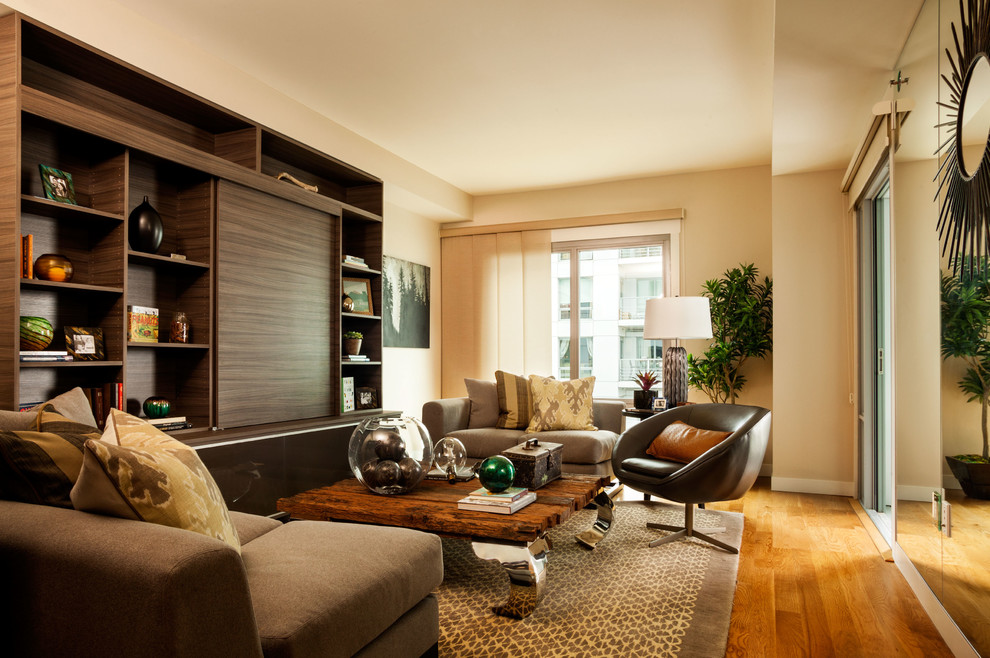 Пример оригинального дизайна: открытая гостиная комната среднего размера в современном стиле с бежевыми стенами, паркетным полом среднего тона и скрытым телевизором
