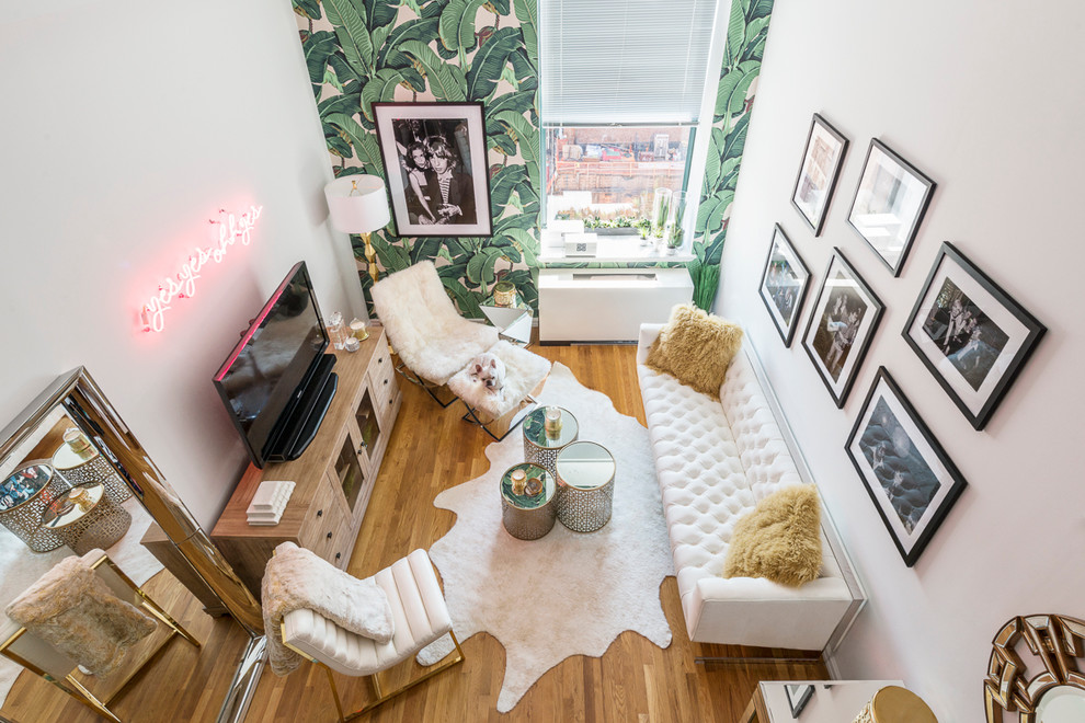 Example of a small trendy loft-style medium tone wood floor living room design in New York with white walls and a tv stand