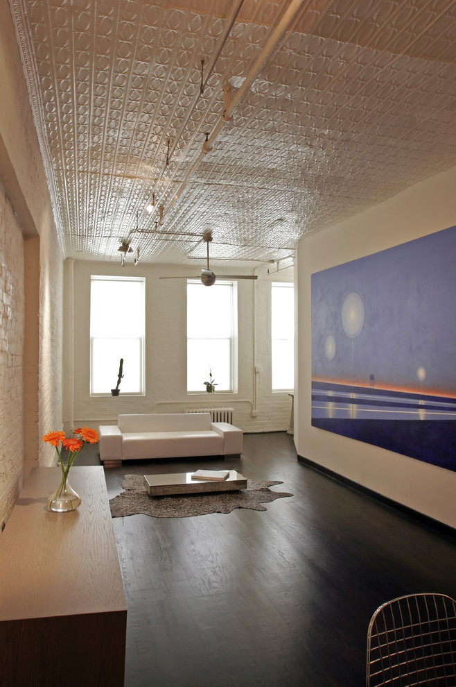 Industrial Wohnzimmer mit weißer Wandfarbe und dunklem Holzboden in New York