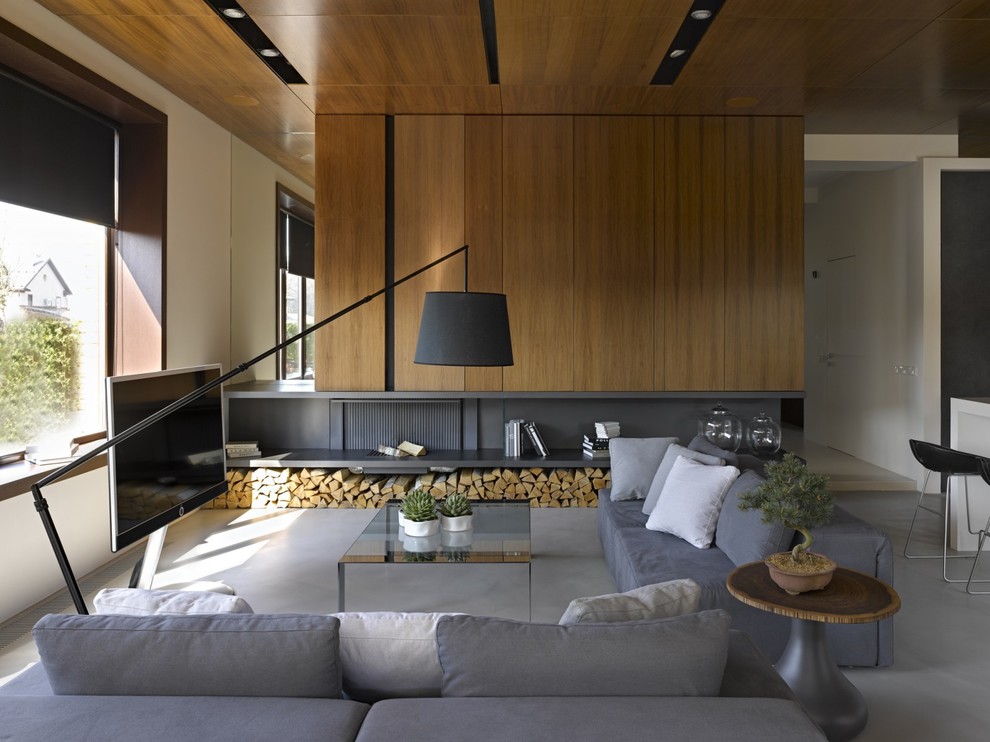 Cette image montre un salon design ouvert avec une salle de réception, un mur blanc, sol en béton ciré, une cheminée standard et un téléviseur indépendant.