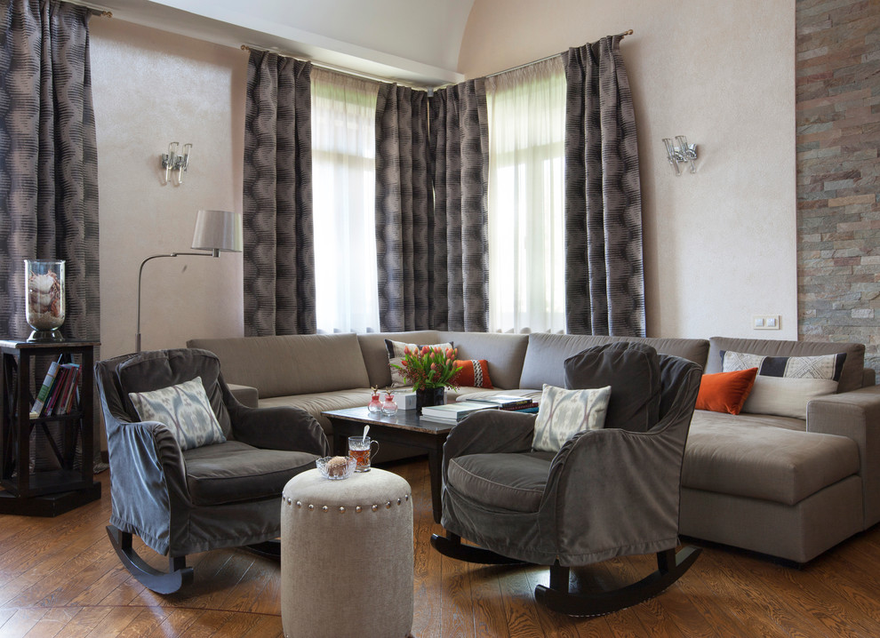 Aménagement d'un salon contemporain avec une salle de réception, un mur beige et un sol en bois brun.