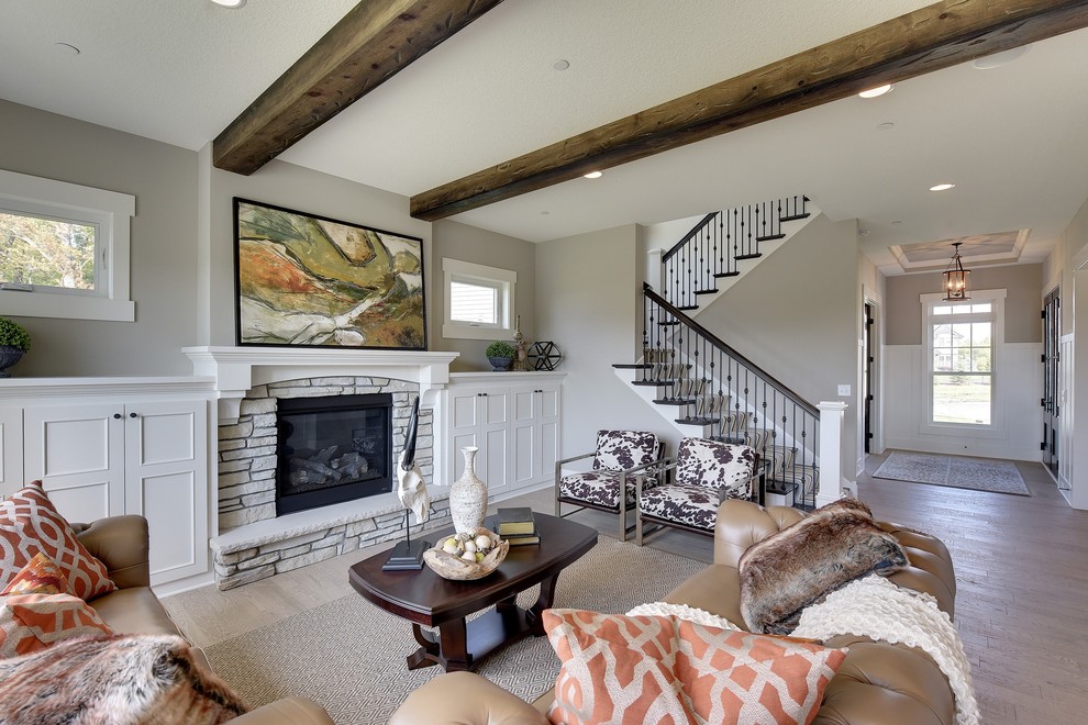 Country grey and white open plan living room in Minneapolis with grey walls, dark hardwood flooring, a standard fireplace, a stone fireplace surround and brown floors.