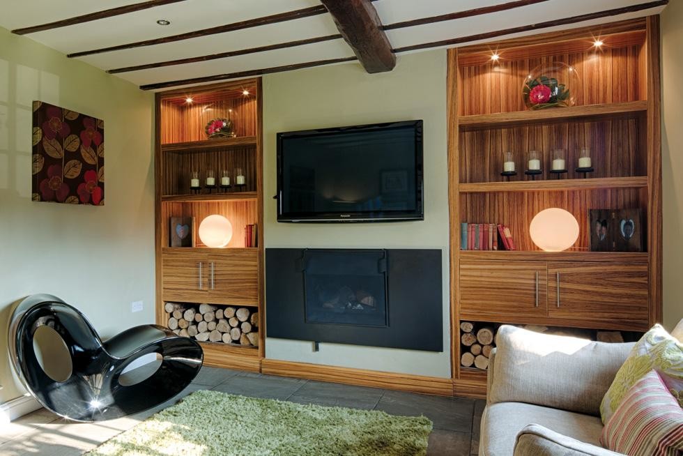 Идея дизайна: маленькая изолированная гостиная комната в современном стиле с с книжными шкафами и полками, зелеными стенами, полом из сланца, печью-буржуйкой, фасадом камина из металла, телевизором на стене и серым полом для на участке и в саду