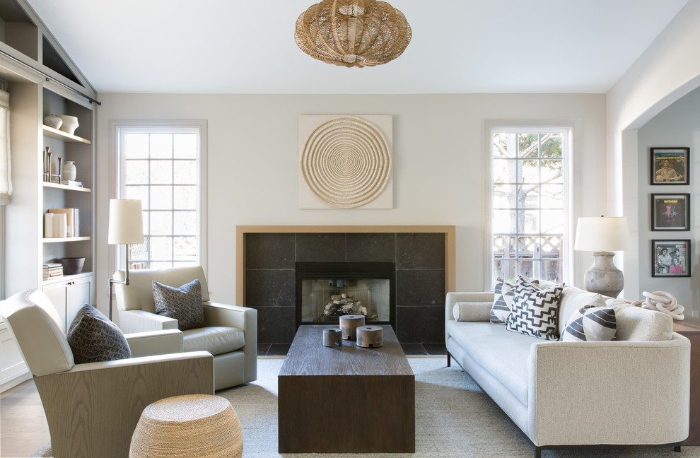 サンフランシスコにある中くらいなトランジショナルスタイルのおしゃれなLDK (淡色無垢フローリング、標準型暖炉、石材の暖炉まわり、テレビなし、茶色い床、ベージュの壁) の写真