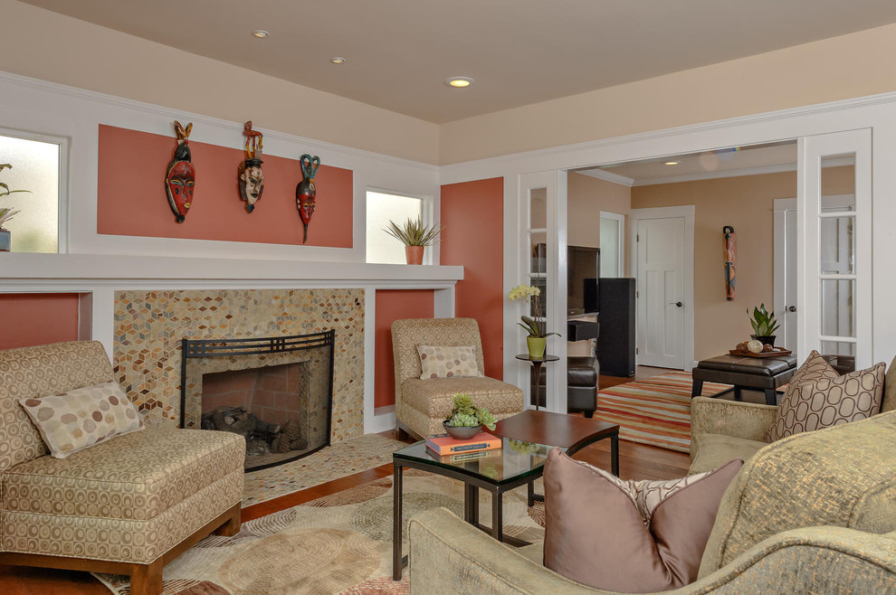 Свежая идея для дизайна: гостиная комната среднего размера в стиле неоклассика (современная классика) с фасадом камина из плитки, оранжевыми стенами, паркетным полом среднего тона и стандартным камином - отличное фото интерьера