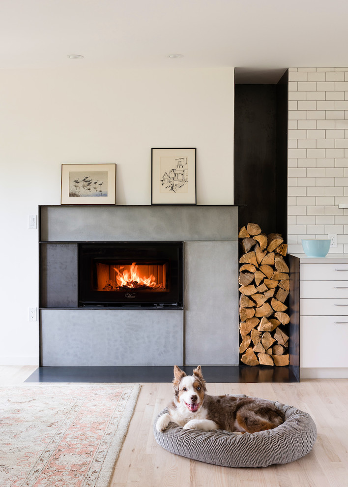 This is an example of a medium sized contemporary open plan living room in Denver with white walls, light hardwood flooring, a standard fireplace, a tiled fireplace surround and no tv.