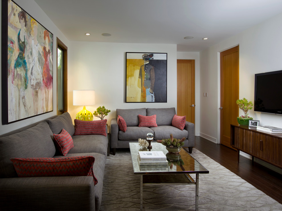 На фото: изолированная гостиная комната в стиле ретро с белыми стенами и телевизором на стене