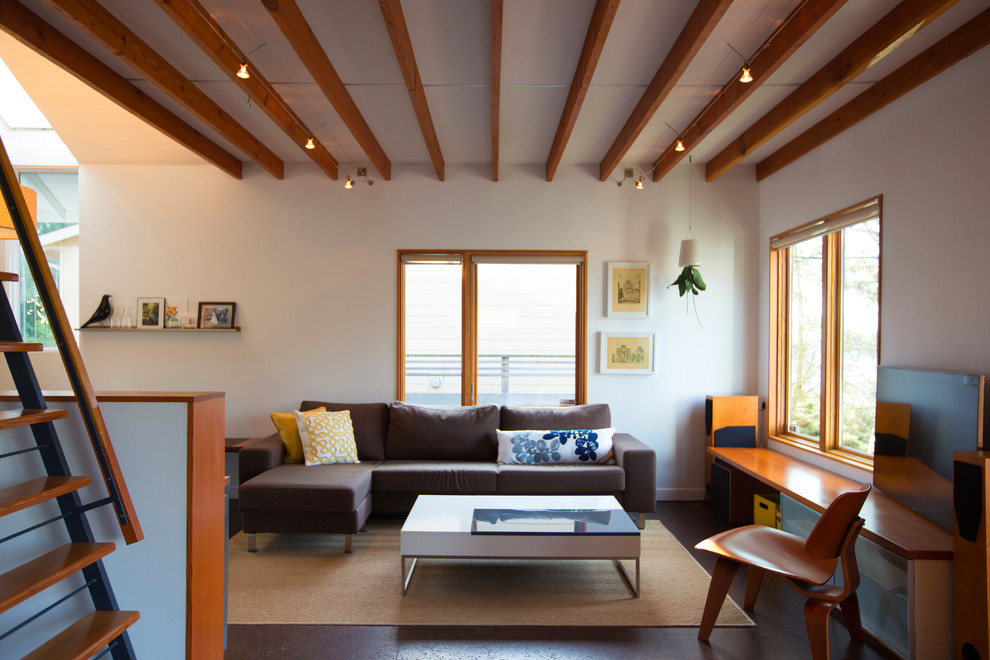 This is an example of a small modern mezzanine living room in Seattle with white walls and cork flooring.
