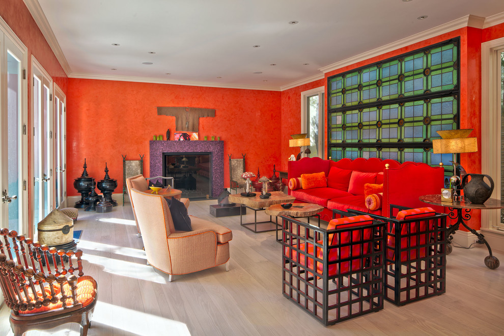 ロサンゼルスにある高級な広いエクレクティックスタイルのおしゃれなリビング (オレンジの壁、淡色無垢フローリング、標準型暖炉、タイルの暖炉まわり、茶色い床) の写真